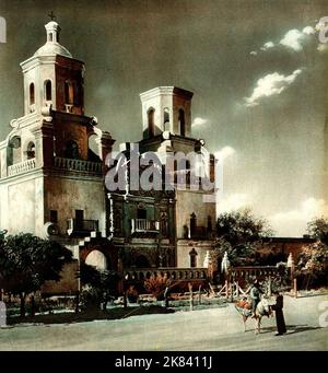 Die Missionskirche von San Xavier del Bac in Arizona im Jahr 1932. Mission San Xavier del Bac ist eine historische spanische katholische Mission, die sich etwa 10 Meilen (16 km) südlich der Innenstadt von Tucson, Arizona, auf dem Tohono O'odham Nation San Xavier Indianerreservat befindet. Die Mission wurde 1692 von Padre Eusebio Kino im Zentrum einer jahrhundertealten Siedlung der Sobaipuri O'odham gegründet, einem Zweig des Akimel oder des O'odham, der sich am Ufer des Santa Cruz Flusses befindet. Stockfoto