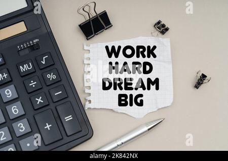 Geschäfts- und Finanzkonzept. Auf dem Tisch steht ein Rechner, ein Stift und Papier mit der Aufschrift - Work Hard Dream Big Stockfoto