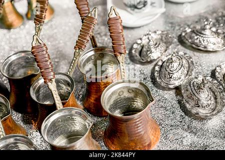 Mehrere kupfertürken zum Kaffeekochen stehen auf dem Tisch, Draufsicht in einem Winkel von 45 Grad Stockfoto