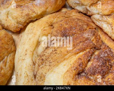 Weidenbrötchen mit Zimt und Zucker. Brot Produkt von einer ungewöhnlichen Form. Hausgemachtes Backen. Brötchen mit einer rohen Kruste. Nahaufnahme von Lebensmitteln Stockfoto