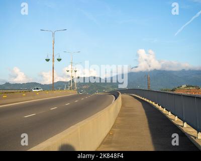 Die Straße geht nach oben. Straßenkreuzung vor der Kulisse der Berge. Asphalt. Maschinenbewegung Stockfoto