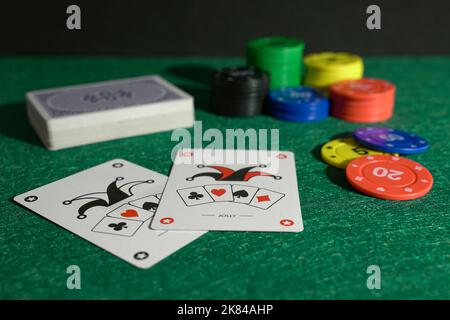 Spielkarten und farbige Chips auf grünem Stoff Stockfoto
