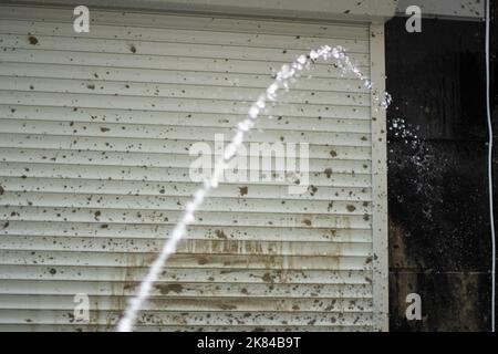 Wasserstrahl und schmutzige Wand. Waschen von Schmutz vom Gebäude. Jet unter Druck. Wasserfluss. Stockfoto