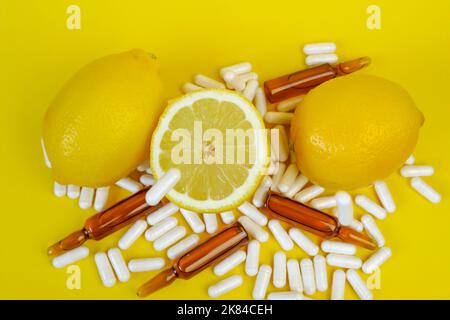 Vitamin-C-Tabletten auf gelbem Hintergrund.Fliegende Vitamin-C-Pillen und Zitronen geschnitten .natürliche Frucht Vitamin C.Immunität Remedy.Gesundheit und Medizin Stockfoto