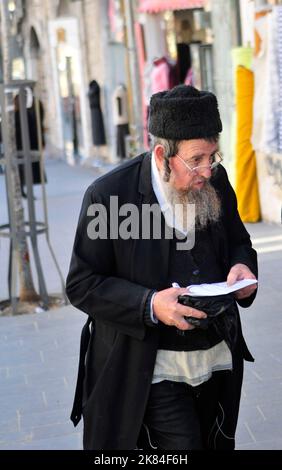 Ein orthodoxer jüdischer Mann, der auf der Jaffa-Straße in Jerusalem, Israel, läuft. Stockfoto