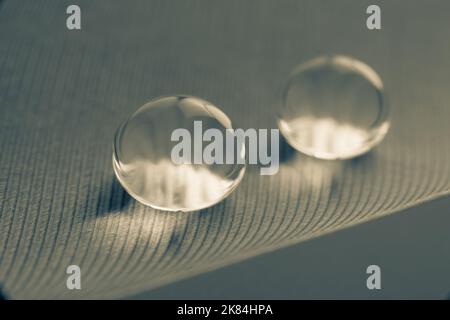 Schöne große Tautropfen oder Regen auf der Geflügelfeder aus der Nähe. Schwarzweiß-Foto Stockfoto