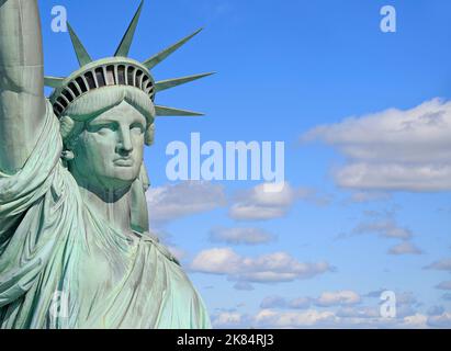 Kopf und Büste der Freiheitsstatue mit blauem Himmel und Wolken im Hintergrund, New York City, USA Stockfoto