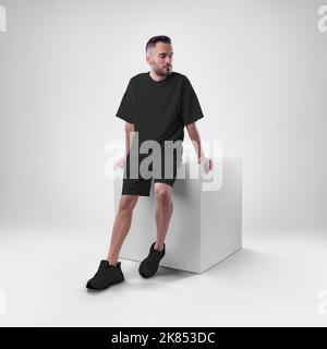 Nachbau eines schwarzen Herrenanzugs übergroßes T-Shirt auf Shorts auf Mann auf Würfel. Bekleidungsvorlage für Präsentationen von Design, Druck, Muster. Stockfoto