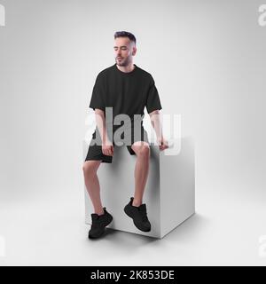 Nachbau eines schwarzen Herrenanzugs übergroßes T-Shirt auf Shorts auf Mann auf Würfel. Bekleidungsvorlage für Präsentationen von Design, Druck, Muster. Stockfoto