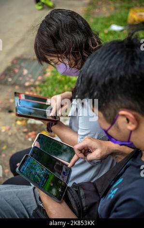 Taipeh. 21. Oktober 2022. Gamer nutzen mehrere Mobiltelefone als Pokemon-Jäger, die sich im Daan Forest Park in Taipei, Taiwan, während der Pokémon GO Safari Zone am 21/10/2022 versammelt haben von Wiktor Dabkowski Credit: dpa/Alamy Live News Stockfoto