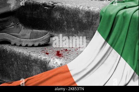 Das Bein des Militärs steht auf der Stufe neben der Flagge Irlands, dem Konzept des militärischen Konflikts Stockfoto