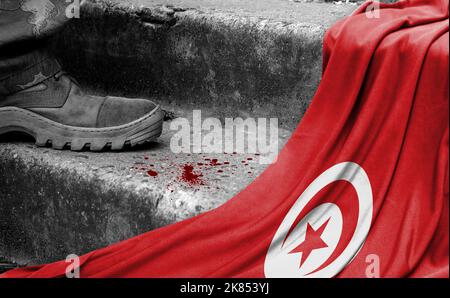 Das Bein des Militärs steht auf der Stufe neben der Flagge Tunesiens, dem Konzept des militärischen Konflikts Stockfoto