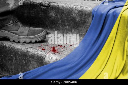 Das Bein des Militärs steht auf der Stufe neben der Flagge der Ukraine, dem Konzept des militärischen Konflikts Stockfoto