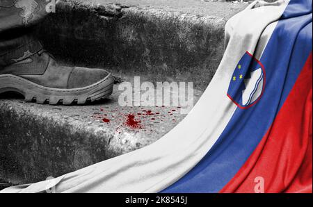 Das Bein des Militärs steht auf der Stufe neben der Flagge Sloweniens, dem Konzept des militärischen Konflikts Stockfoto