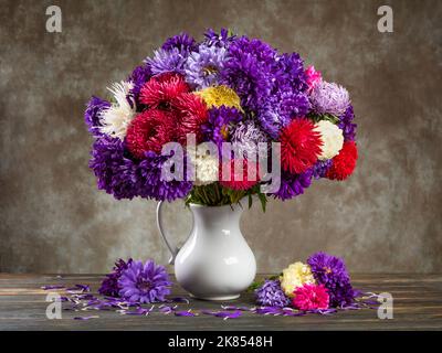 Schöner Strauß herbstlicher Aster auf einem Holztisch. Stockfoto