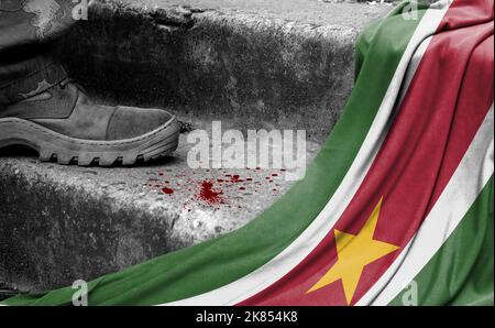 Das Bein des Militärs steht auf der Stufe neben der Flagge von Suriname, dem Konzept des militärischen Konflikts Stockfoto