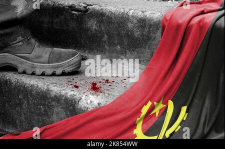 Das Bein des Militärs steht auf der Stufe neben der Flagge Angolas, dem Konzept des militärischen Konflikts Stockfoto