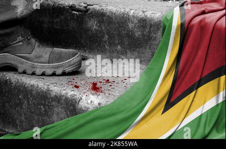 Das Bein des Militärs steht auf der Stufe neben der Flagge von Guyana, dem Konzept des militärischen Konflikts Stockfoto