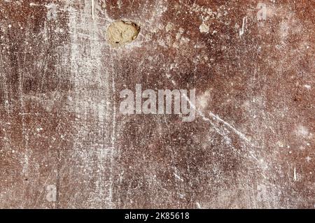 Textur einer Betonwand mit Rissen und Kratzern, die als Hintergrund verwendet werden kann. Alte Zementwand, kaputte Wand Stockfoto