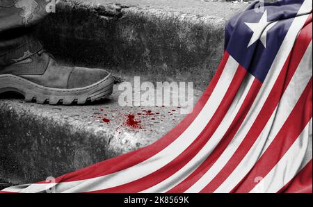 Das Bein des Militärs steht auf der Stufe neben der Flagge Liberias, dem Konzept des militärischen Konflikts Stockfoto