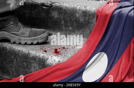 Das Bein des Militärs steht auf der Stufe neben der Flagge von Laos, dem Konzept des militärischen Konflikts Stockfoto