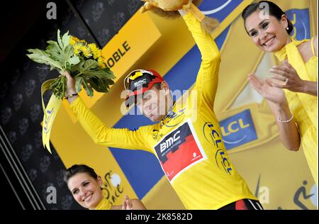 Cadel Evans vom BMC Racing Team feiert die Übernahme der Gesamtführung im gelben Trikot auf dem Podium nach der 20. Etappe Stockfoto