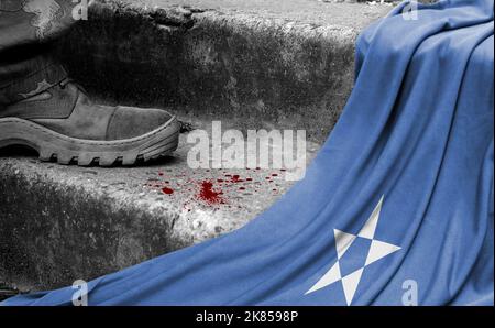 Das Bein des Militärs steht auf der Stufe neben der Flagge Somalias, dem Konzept des militärischen Konflikts Stockfoto