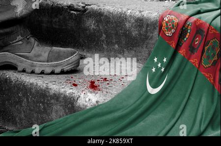 Das Bein des Militärs steht auf der Stufe neben der Flagge Turkmenistans, dem Konzept des militärischen Konflikts Stockfoto