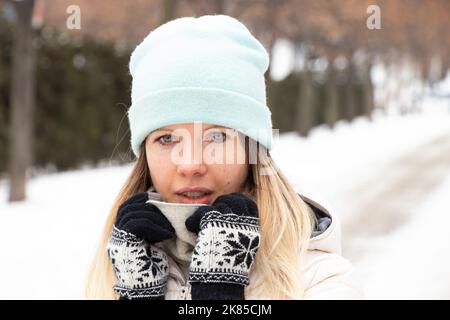 Mädchen im Winter im Winter Kleidung in der Stadt für einen Spaziergang, Porträt eines Mädchens auf der Straße im Winter Stockfoto