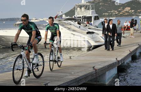 Thomas Voeckler von Team Europcar im hinteren Teil der Gruppe geht auf die Bühne, wo das Team für die Tour de France 100. in Portoo vecchio ansteht. Mit dem Fahrrad von einem im Hafen verankerten Motorboot auf die Bühne. Stockfoto