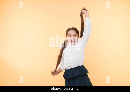 Bequeme und einfache Frisur. Befassen Sie sich mit langen Haaren Frisur von selbst. Kid girl lange Pferdeschwanz Frisur. Kinderschuluniform Frisur machen. Kind Stockfoto