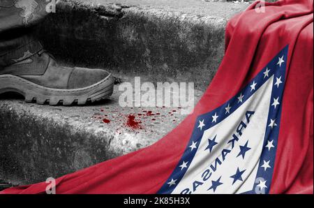 Das Bein des Militärs steht auf der Stufe neben der Flagge des Staates Arkansas, dem Konzept des militärischen Konflikts Stockfoto