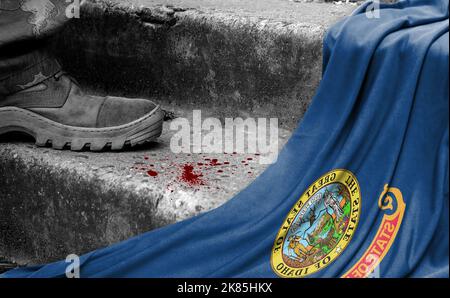Das Bein des Militärs steht auf der Stufe neben der Flagge des Staates Idaho, dem Konzept des militärischen Konflikts Stockfoto