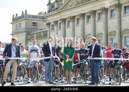 Herzogin und Duke of Cambridge und Prinz Harry schneiden zu Beginn des Rennens im Harewood House das Band, während Chris Froome hinter sich sieht Stockfoto