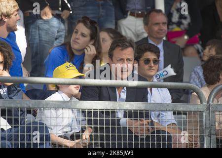 Der britische Premierminister David Cameron sitzt in Harrogate an der Zieltribüne und wartet auf das Rennen während der ersten Etappe der Tour de France 2014. Stockfoto