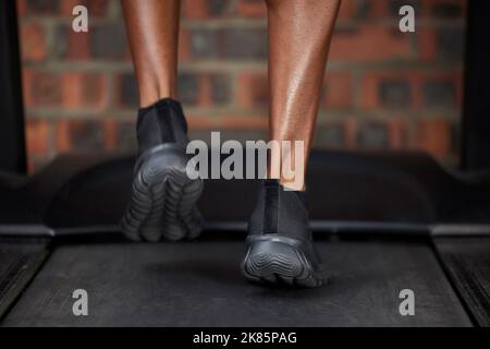 Läufer, Füße und Schuhe auf dem Laufband beim Fitnesstraining, Training und Training für Herz-Kreislauf-Gesundheit, Wellness und Energie. Zoom, schwarzer Mann und Sport Stockfoto