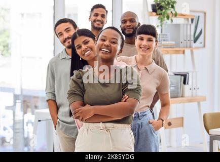 Wenn eine Gruppe ehrgeiziger Menschen zusammenkommt, passieren großartige Dinge. Eine Gruppe von Geschäftsleuten, die in einem Büro zusammenstehen. Stockfoto