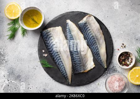 Roher, frischer Filet-Makrelenfisch mit aromatischen Kräutern, Gewürzen, Zitrone und Olivenöl Stockfoto