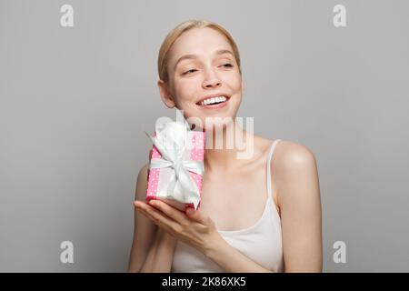Nahaufnahme Porträt von schönen attraktiven schönen wunderschönen aufgeregt fröhlich Frau genießen halten rosa Geschenk auf weißem Hintergrund Stockfoto