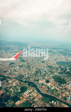 Eine vertikale Aufnahme eines Stadtpanoramas aus dem Flugzeugfenster Stockfoto