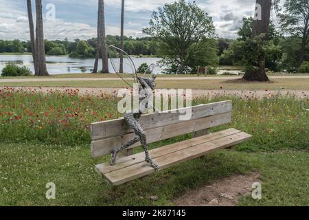 Trentham Gardens Draht Fee sitzen auf Bank sonnigen Tag mit Wolken, Staffordshire UK. Stockfoto