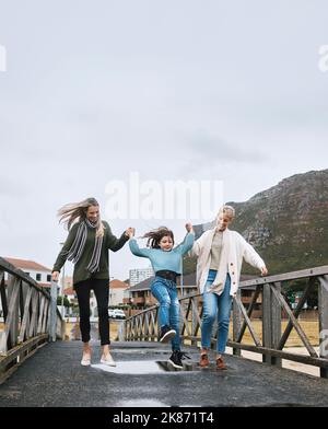 Glücklich, reisen und Familie auf Outdoor-Spaziergang während eines Frühlingsurlaubs, Abenteuer oder Reise. Großmutter, Mutter und Kind auf der Brücke Stockfoto