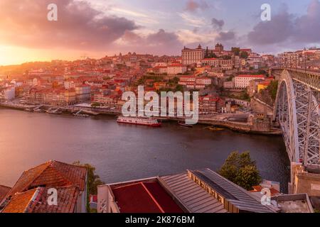 Blick auf die Brücke Dom Luis I über den Douro River, die bei Sonnenuntergang mit farbenfrohen Gebäuden in Richtung Ribeira, UNESCO, ausgerichtet ist Stockfoto