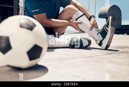 Fußball, Fitness oder Mann mit Beinverletzung beim Training, Training oder Fußballtraining auf dem Dach des Gebäudes im Freien. Wellness, Gesundheit oder Fußballspieler Stockfoto