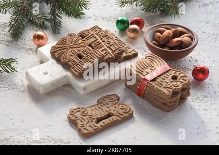 SPECULOOS oder Spekulatius, Weihnachtsgebäck, Schokoladenkugeln und Mandeln auf einem Tisch mit Tannenzweigen. Traditionelle deutsche Süßigkeiten, Kekse zu Weihnachten Stockfoto