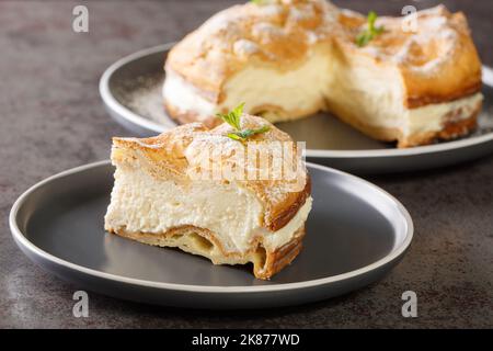 Authentische polnische Karpatenkuchen Karpatka Nahaufnahme auf dem Teller auf dem Tisch. Horizontal Stockfoto