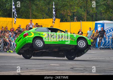 FRANKFURT AM MAIN, DEUTSCHLAND - 2022. SEPTEMBER: Grünes BMW 325i E36 Auto fährt seitwärts auf zwei Rädern, auf einer Auto Show, Monster Truck Auto Show. Stockfoto