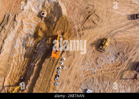 Baustelle ein Bagger Graben für die Verlegung von Kanalleitungen und Anschluss von Regenwasserkanalrohren im Untergrund. Stockfoto