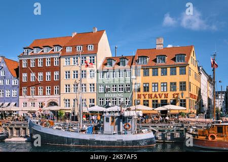 Kopenhagen, Dänemark - 2022. September: Farbenfrohe, traditionelle Hausarchitektur und Boote am Ufer des Kanals im Nyhavn-Hafen Stockfoto