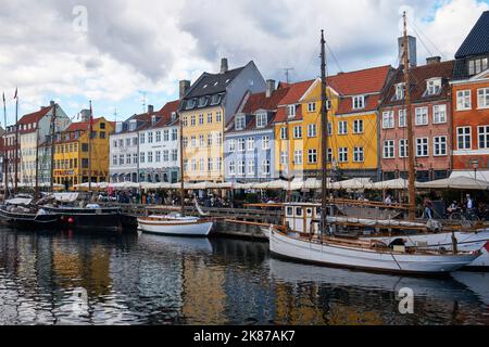 Kopenhagen, Dänemark - 2022. September: Farbenfrohe, traditionelle Hausarchitektur und Boote am Ufer des Kanals im Nyhavn-Hafen Stockfoto